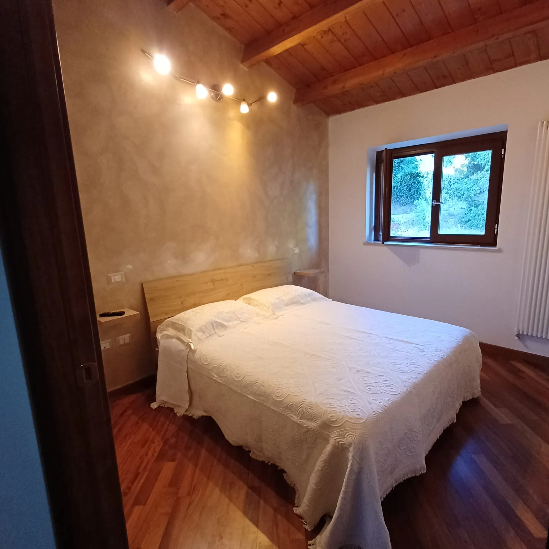 Camera matrimoniale con pavimento e soffitto in legno